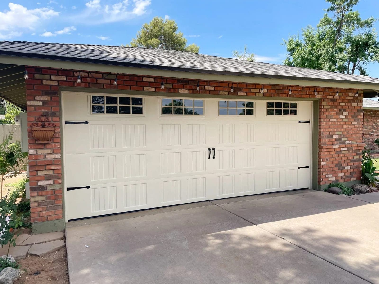 Cream carriage-house garage door with windows maintained by Morning Star